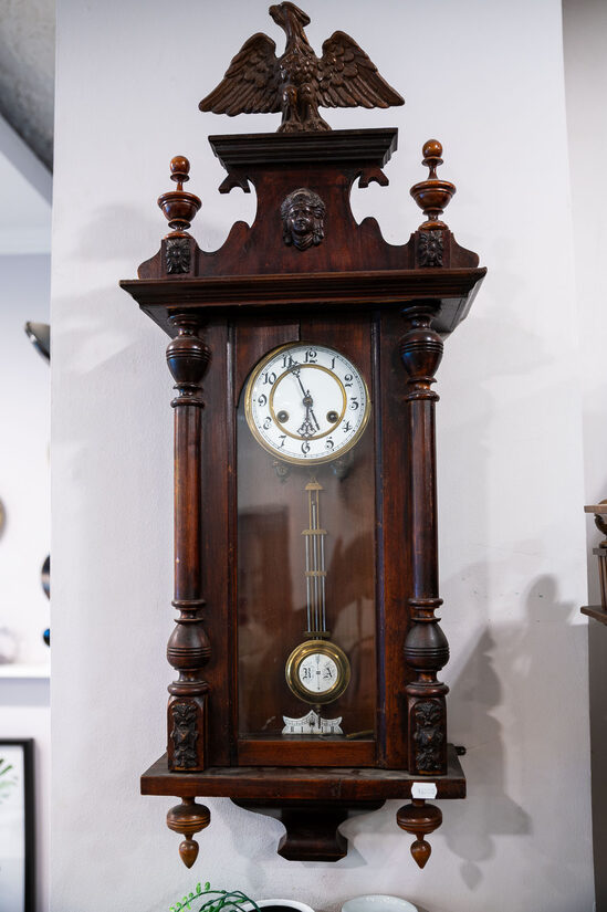 Liels, antīks uzvelkams sienas pulkstenis ar grebtu ērgli